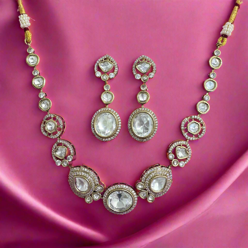 Ornate necklace and earrings set on a pink background